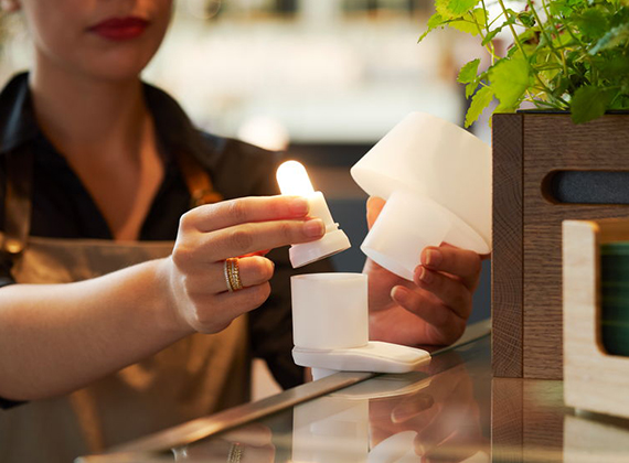 Waitress placing LED light into candle holder