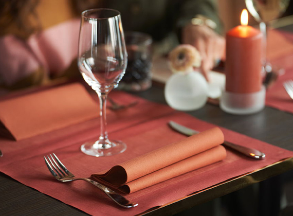 Terracotta coloured linen feel napkin on coordinating placemat