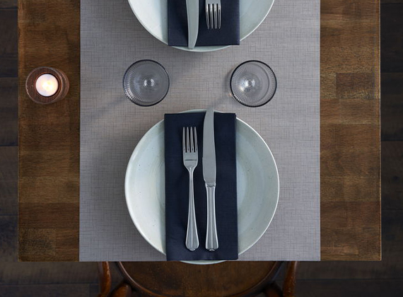 Napkin and cutlery on large placemat and table runner